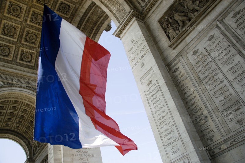 FRANCE, Ile de France, Paris, The French Triclour flag flying beneath the central arch of the Arc de Triomphe