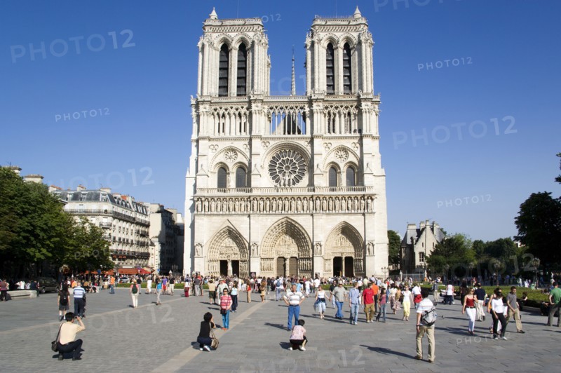 FRANCE, Ile de France, Paris, Tourists in the suare at the west front of the Gothic style Notre Dame Cathedral on Ile de la Cite