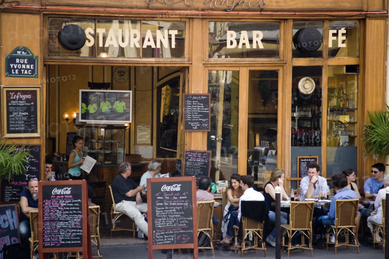 FRANCE, Ile de France, Paris, Montmartre People sitting at pavement tables outside a cafe on Rue Yvonne le Tac