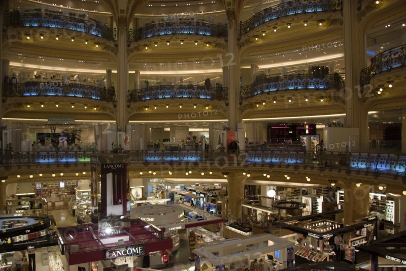 FRANCE, Ile de France, Paris, Opera Quarter. The central circular area under the glass dome of the Art Nouveau department store Galleries Lafayette showing the balconies and the perfume department on the ground floor