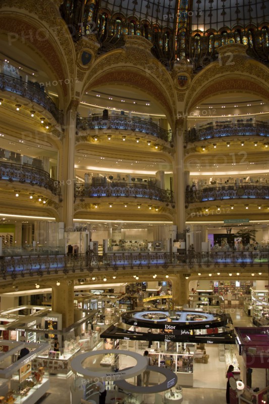 FRANCE, Ile de France, Paris, Opera Quarter. The central circular area under the glass dome of the Art Nouveau department store Galleries Lafayette showing the balconies and the perfume department on the ground floor