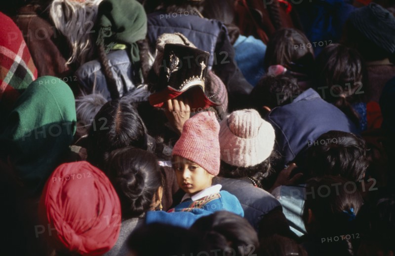 INDIA, Ladakh, Hemis Gompa, "Child in crowd of pilgrims reaching for Holy Thangka of Padmasambhava during Hemis Festival to celebrate the birth of Guru Padmasambhava, founder of Tibetan Buddhism."
