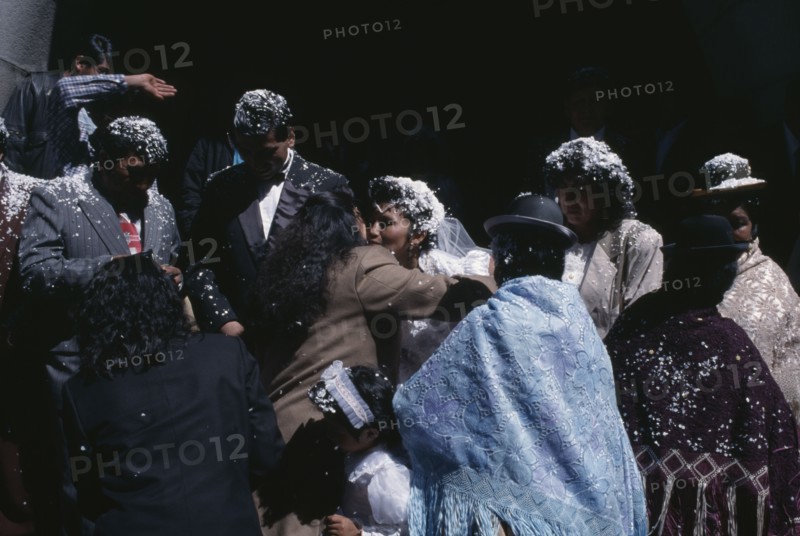 BOLIVIA, La Paz, Friends and family congratulate wedding bride and groom covered with white confetti on the steps of the Basilica de San Francisco.