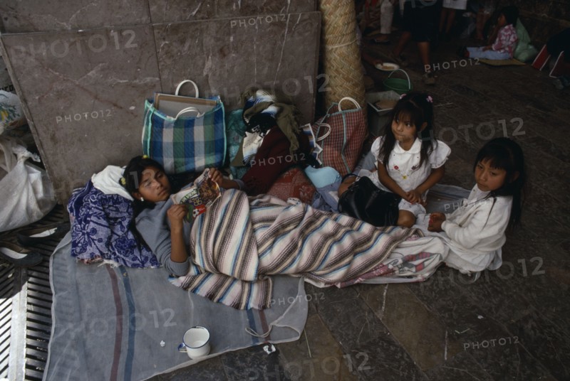 MEXICO, Mexico State, Chalma, Young woman and children on pilgrimage to Chalma resting on roadside surrounded by belongings.