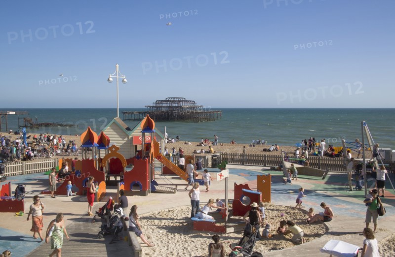 ENGLAND, East Sussex, Brighton, Childrens play area with the ruins of the West Pier behind.