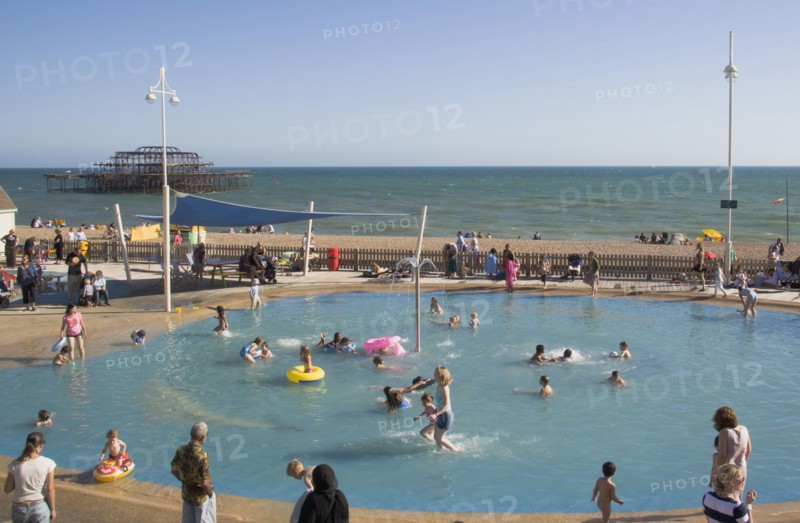 ENGLAND, East Sussex, Brighton, Childrens paddling pool with the ruins of the West Pier behind.