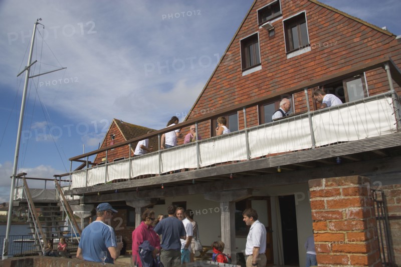 ENGLAND, Hampshire, Emsworth, People sat outside the yacht club.