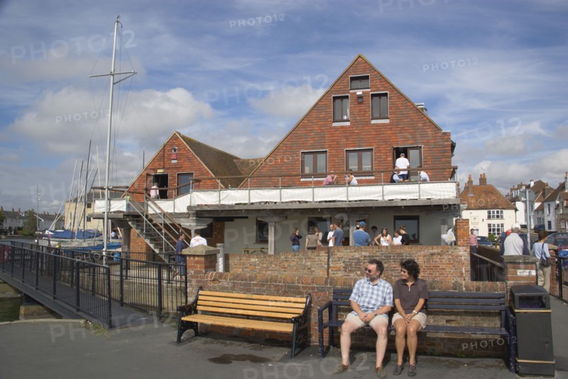 ENGLAND, Hampshire, Emsworth, People sat outside the yacht club.