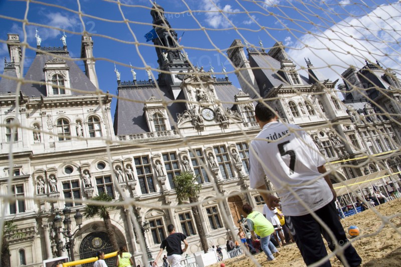 FRANCE, Ile de France, Paris, The Paris Plage urban beach. Boy wearing a Zidane football shirt playing in goal during a beach soccer childrens match in front of the Hotel de Ville Town Hall