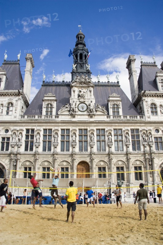 FRANCE, Ile de France, Paris, The Paris Plage urban beach. Young people playing beach volleyball in front of the Hotel de Ville Town Hall