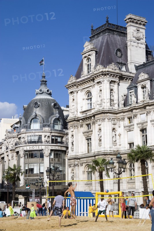 FRANCE, Ile de France, Paris, The Paris Plage urban beach. Young people playing beach volleyball in front of the Hotel de Ville Town Hall