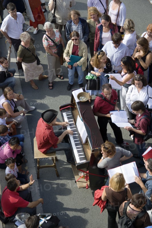 FRANCE, Ile de France, Paris, The Paris Plage urban beach. A singer playing a piano to an audience under the Pont Notre Dame on the Voie Georges Pompidou a usually busy road closed to traffic