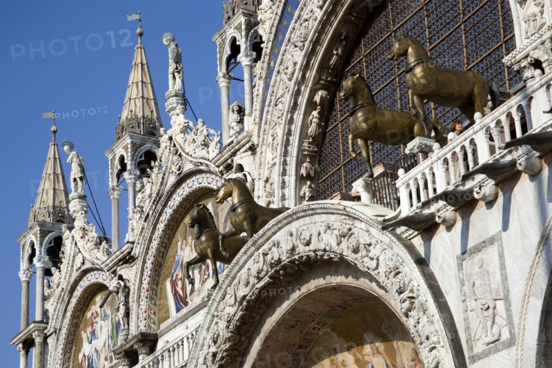 ITALY, Veneto, Venice, The bronze Horses of St Mark and the 17th Century mosaics on the facade of St Marks Basilica with tourists on the viewing balcony