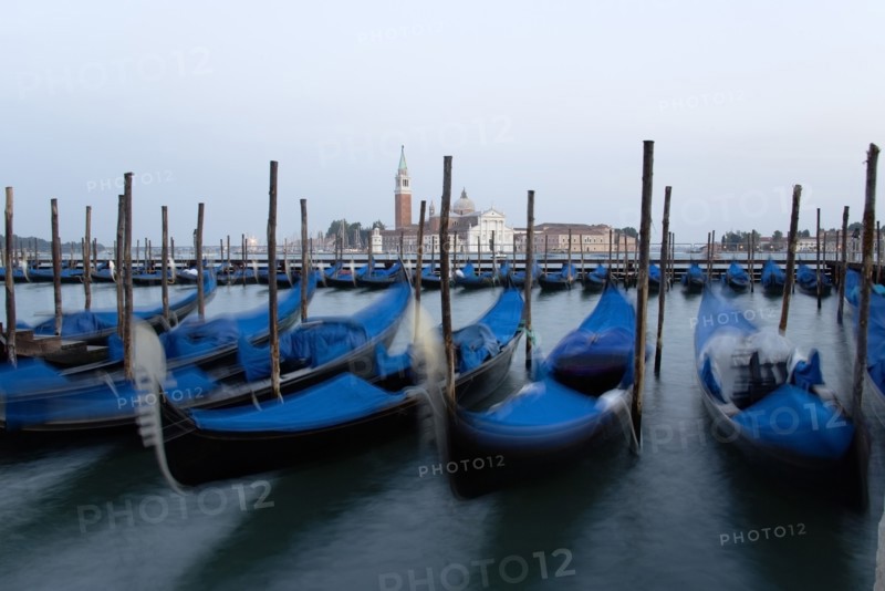 ITALY, Veneto, Venice, Gondolas moored at dusk in the Molo San Marco basin with Palladio's church of San Giorgio Maggiore on the island of the same name in the distance