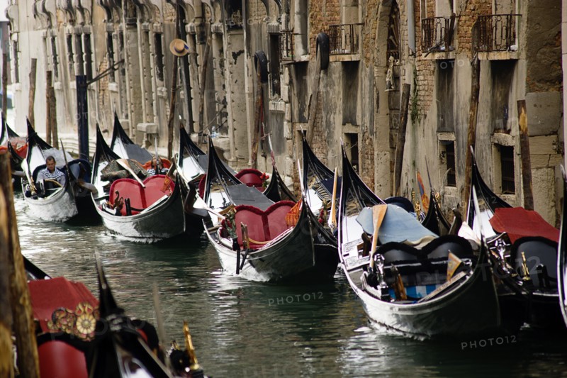 ITALY, Veneto, Venice, Gondoliers resting in their gondolas moored along the Rio San Moise canal
