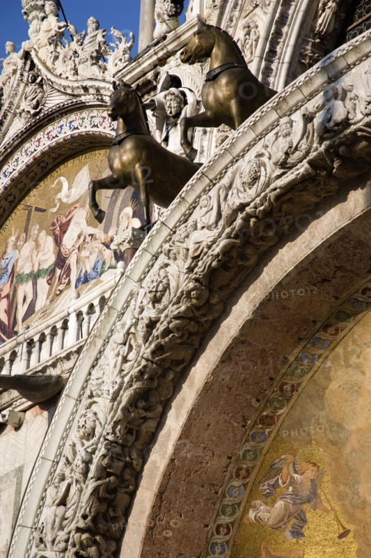 ITALY, Veneto, Venice, Two of the four bronze Horses of St Mark above the central doorway on the facade of the Basilica Can Marco with its 17th Century religious mosaics