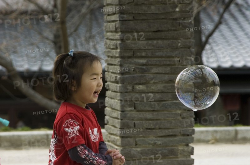 JAPAN, Honshu, Kyoto, Child playing with bubbles near Maruyama-koen Park