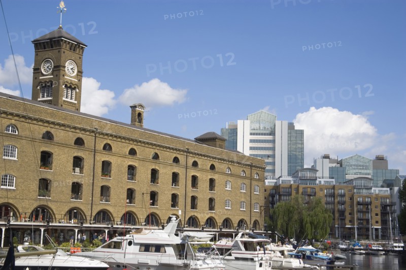 ENGLAND, London, St Catherine’s Dock with yachts moored next to the former warehouses which are now luxury apartments.