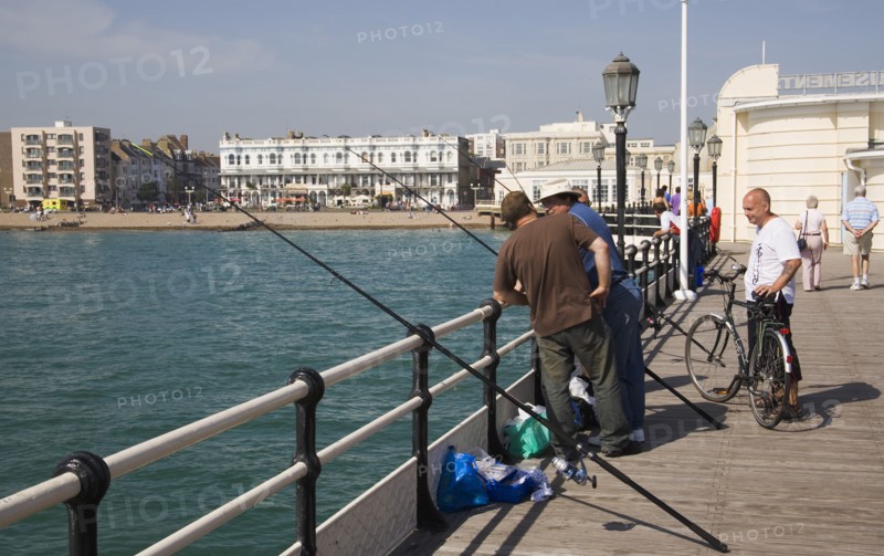 ENGLAND, West Sussex, Worthing, Men fishing off the pier