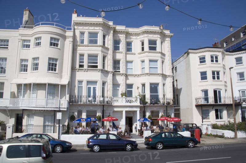 ENGLAND, West Sussex, Worthing, The Last Resort seafront bar exterior with people sitting  under parasols drinking