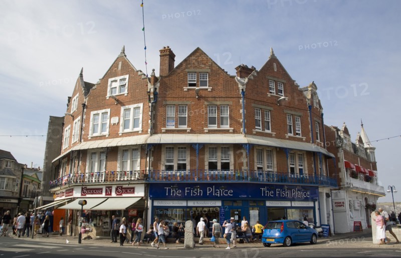 ENGLAND, Dorset, Swanage, Shop fronts in the town centre with The Fish Plaice Fish and Chip shop.