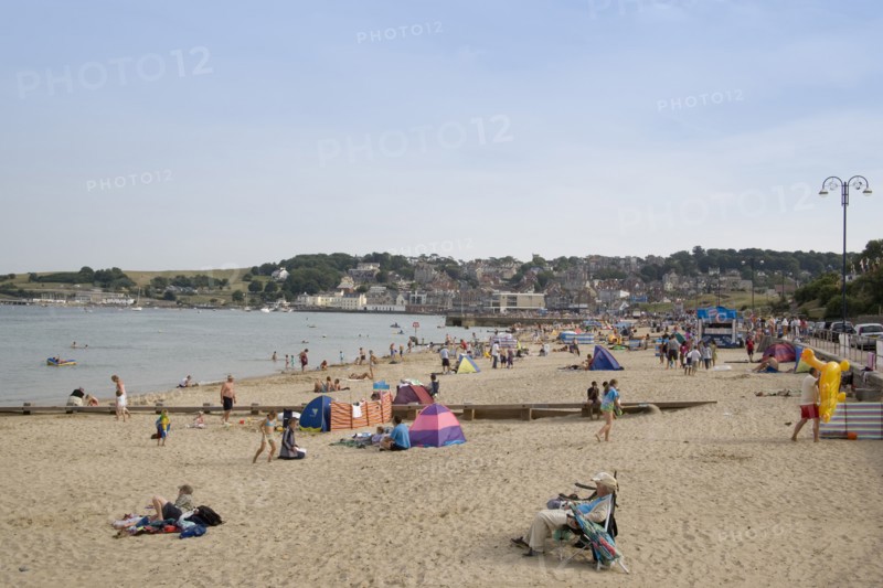 ENGLAND, Dorset, Swanage Bay, View along sandy beach with sunbathers on the sand