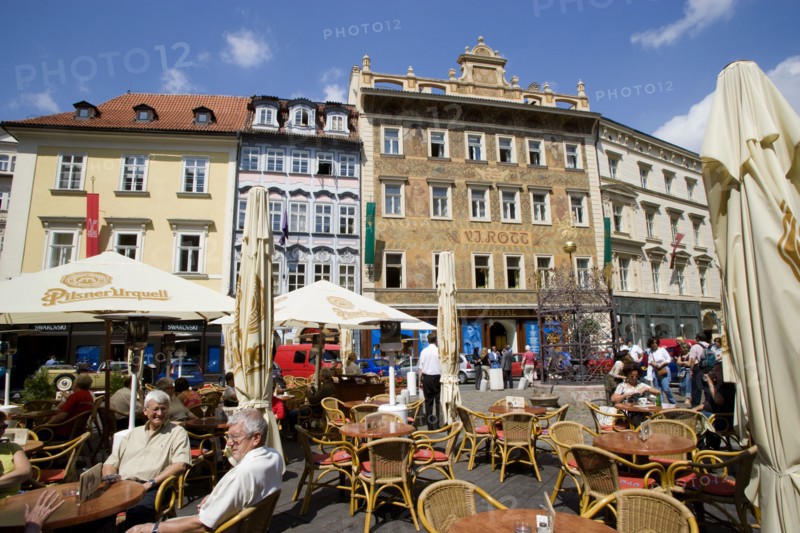 CZECH REPUBLIC, Bohemia, Prague, Old Town. People sitting at tables with umbrellas at street cafe in Male Namesti