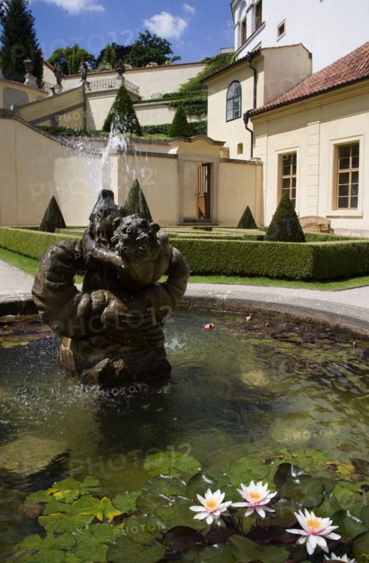 CZECH REPUBLIC, Bohemia, Prague, Fountain and water lillies set amonsgt trimmed box hedging and conifers at The Vrtba Gardens in the Little Quarter