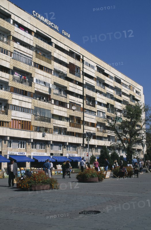 KAZAKHSTAN, Almatr, Street scence with people selling paintings in front of shops and apartrments.