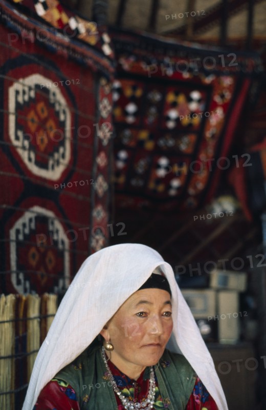 AFGHANISTAN, People, Kirghiz woman sat in yurt wearing traditional dress.