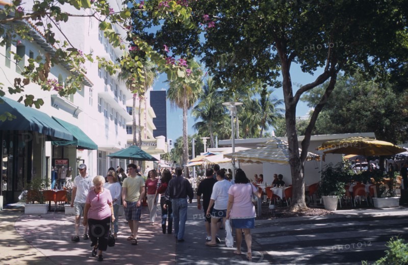USA, Florida, Miami, South Beach. Lincoln Avenue. People walking under trees on pedestrian promenade lined with shops and street cafes near The Lincoln Theatre