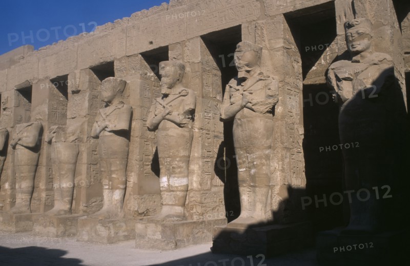EGYPT, Nile Valley, Karnak, Temple of Amun. Osiride Pillars. Statues with crossed arms bearing the crook and flail