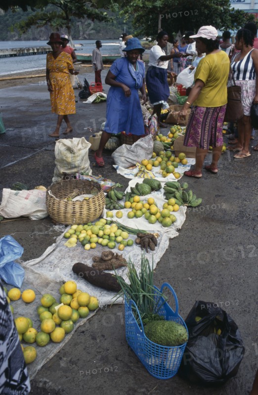 ST LUCIA, Soufriere, "Fruit and vegetable vendors and customers at roadside market.  Yams, oranges, soursop and limes amongst produce for sale."