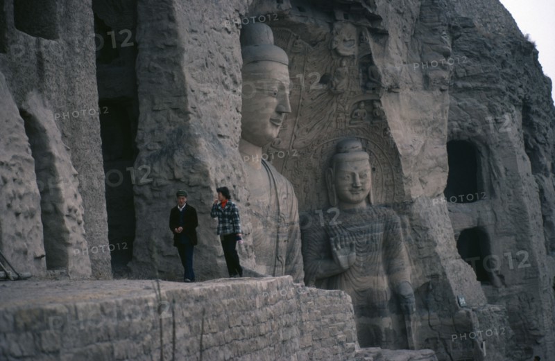 CHINA, Shanxi, Datong, Yungang Caves.  Chinese visitors at ancient Buddhist site with carvings dating from AD 386 - 534.