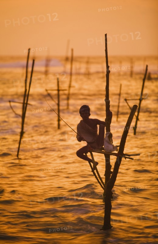 SRI LANKA, Weligama, A lone stilt fisherman at sunset near Weligama.