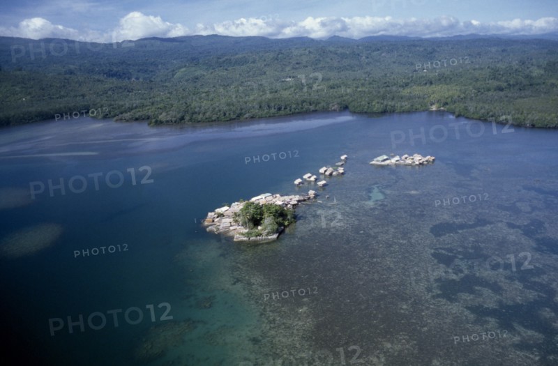 PACIFIC ISLANDS, Melanesia, Solomon Islands, "Malaita Province, Lau Lagoon, Foueda Island.  Aerial view over artificial man made island and houses with mainland covered by dense forest beyond. "