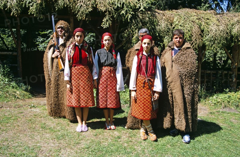 BULGARIA, Pirin Mountain, Chalin Valog, Girls dressed in Bulgarian national costume and men dressed as hunters.