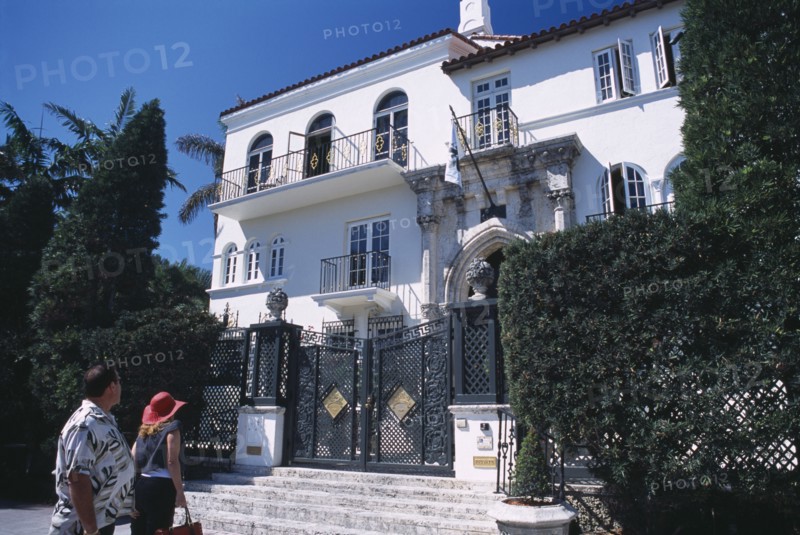 USA, Florida, Miami, South Beach. Ocean Drive. Gianni Versace’s Mansion Casa Casuarina. Man and woman viewing the front exterior from the bottom of entrance steps