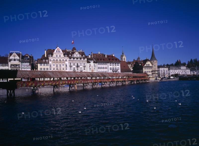 SWITZERLAND, Lucerne Central, Lucerne, Kappelbrucke flower decked covered bridge spanning across The River Reuss.