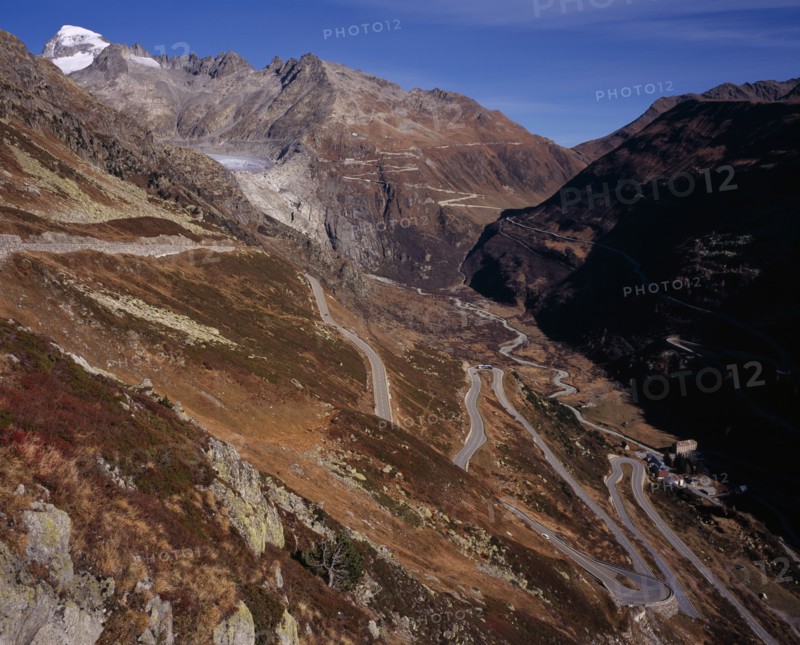 SWITZERLAND, Valais, Grimsel Pass, The Upper Rhone Valley with the Grimsel Pass in the foreground. The distant Furka Pass seen winding above. Snow covered Galenstock Mountain 3586metres  (11744ft ) on the left