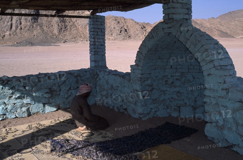 EGYPT, Religion, Islamic, Bedouin man worshipping in Eastern Desert Mosque made with brick and painted turquoise