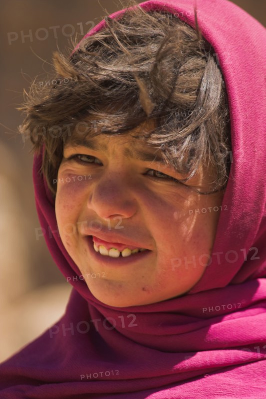 AFGHANISTAN, Bamiyan Province, Bamiyan , Girl that lives in a cave in the cliffs near empty niche where the famous carved small Budda once stood 180 foot high before being destroyed by the Taliban in 2001