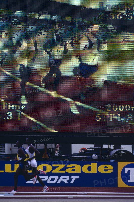20085195 SPORT Athletics Running Male athletes at a meeting running past an electronic viewing screen