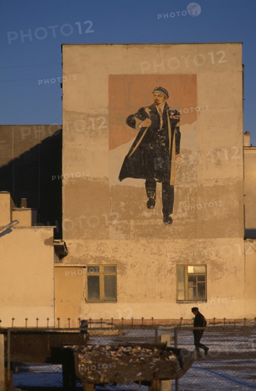 MONGOLIA, Hovd Province, Architecture, Wall painting depicting Lenin on building in Hovd sum centre with passing figure in middle foreground.