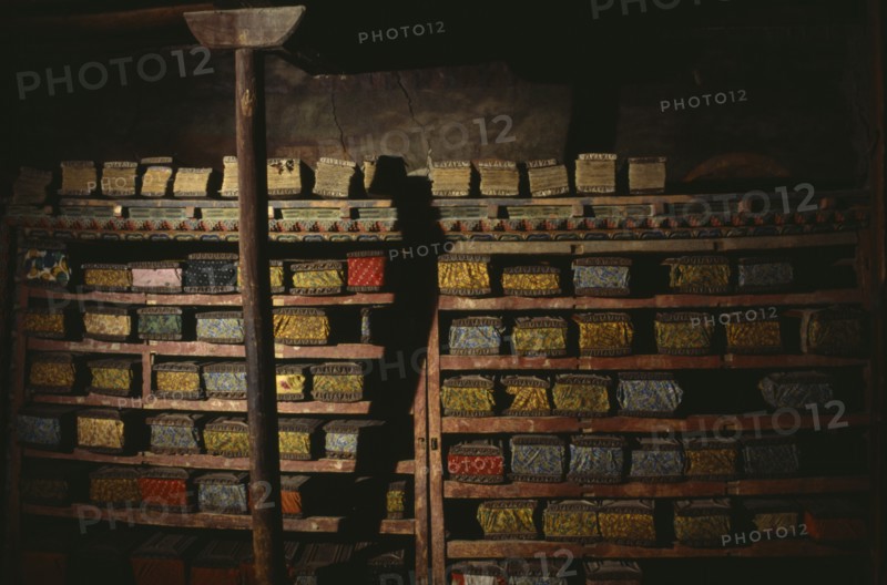 NEPAL, Mustang, Tsarang, "Ancient sacred texts stored in library of old palace of Tsarang, their volumes kept between intricately carved covers."