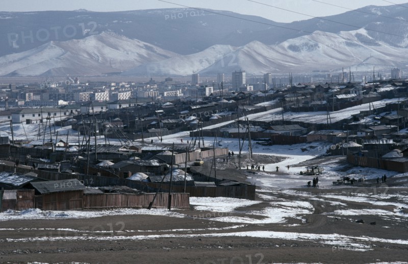 MONGOLIA, Ulan Bator, Traditional housing surrounding Soviet built city centre in winter snow with mountain backdrop.