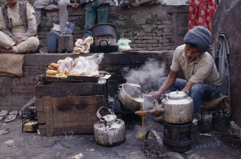 NEPAL, Markets, Food and Drink, Tea-wallah preparing tea boiled with milk and sugar and served in glasses to sell in market.