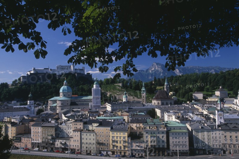 AUSTRIA, Salzburg, "City view from Hettwerr Bastion, part of the old city walls on Kapuzinerberg Hill.  Part framed by tree branches."