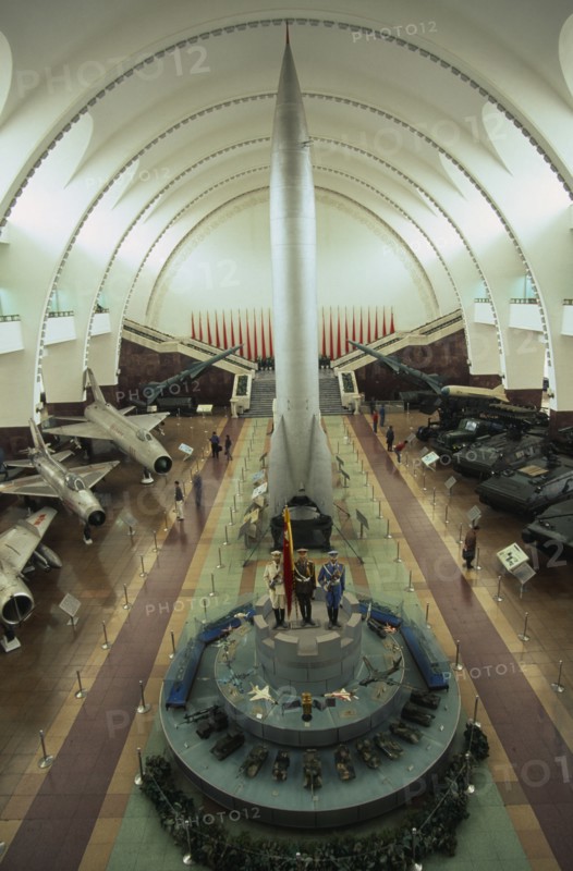 CHINA, Beijing, "Interior hall of the Chinese Military Museum with visitors looking at display of military aircraft, tanks and missiles."