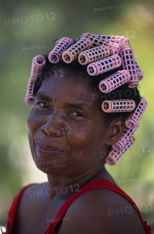 DOMINICAN REPUBLIC, Rodriguez, Head and shoulders portrait of Creole woman with her hair in pink plastic curlers.